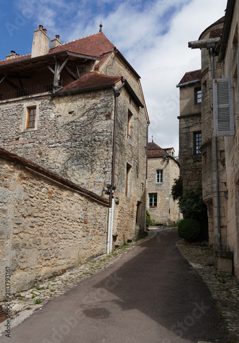 French village Flavigny-sur-Ozerain with medieval walls, winding street lined with beautiful houses. Summer, june.