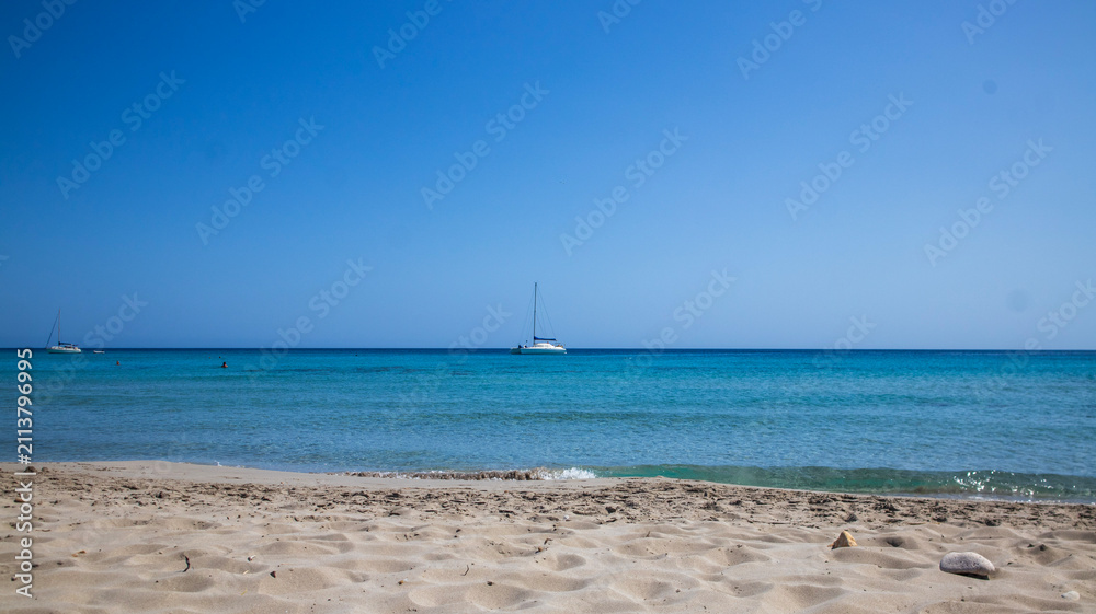 Fototapeta premium Sailboat Sailing on Calm Ocean under Clear Blue Sky