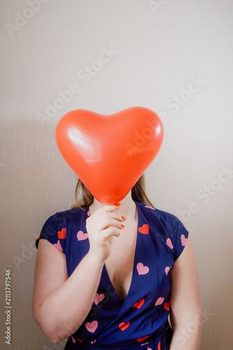Фотография Woman holding a red heart balloon
