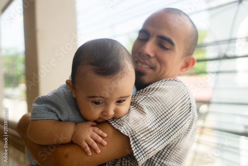 Fotografie Father holding baby in arms showing attachment