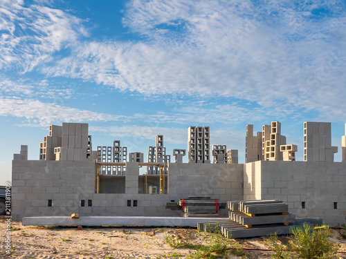 Fotografie Construction site, at the masonry stage, of a hurricane-resistant house in a suburban residential development on a sunny morning in southwest Florida