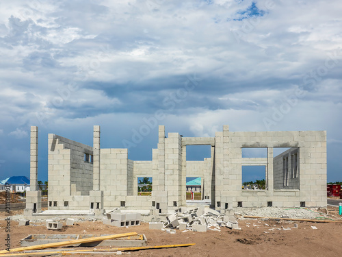 Bild auf Leinwand Concrete shell of a single-family house under construction, with a small pile of