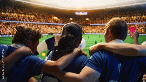 Bild auf Leinwand Soccer supporters embrace in a packed stadium while watching a football game, swaying with the crowd and sharing friendship in a live sports arena