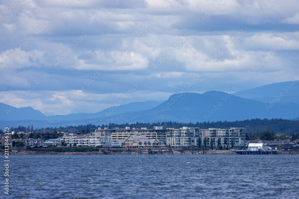 Fototapeta premium Sidney Waterfront Town on Vancouver Island With Mountains, Harbour Buildings and Dramatic Cloudy Sky