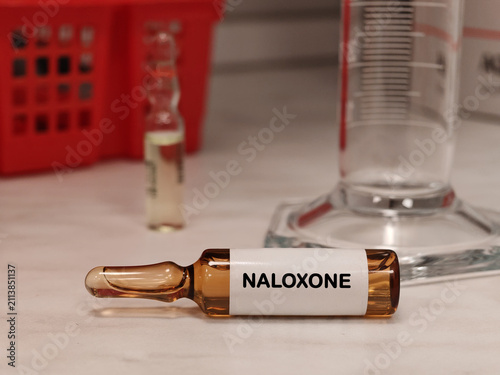 NALOXONE opioid antagonist for emergency overdose reversal in an injectable vial medical ampoule on a clinical laboratory table