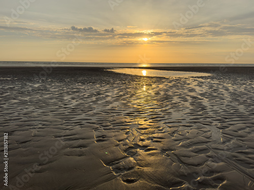 Canvastavla Golden sunset reflecting across rippled sand at low tide