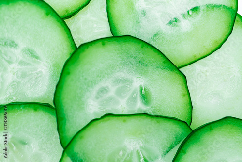 Bild auf Leinwand Sliced cucumbers arranged in overlapping pattern, vibrant green slices, crisp te