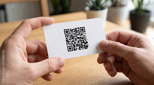 Person Holding Blank Business Card with QR Code in Natural Light Setting