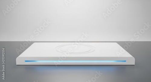 Modern white wireless charging pad sits on a sleek reflective surface.