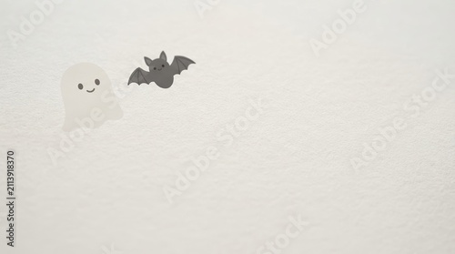 Minimalist Halloween wallpaper with cute ghost and bat illustration on textured white background representing spooky season and fun autumn holiday spirit for design projects
