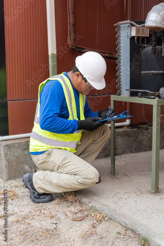 Hvac technician performing scheduled maintenance on an industrial unit