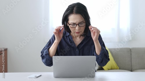 パソコンを使う老眼の中高年女性