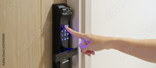Hand press PIN number for smart digital door lock while open or close the door at home or apartment. NFC Technology, Fingerprint scan, keycard, smartphone and contactless lifestyle concepts