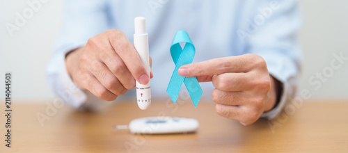 Fotografija Hand show Blue Ribbon and digital blood glucose meter with lancet pen