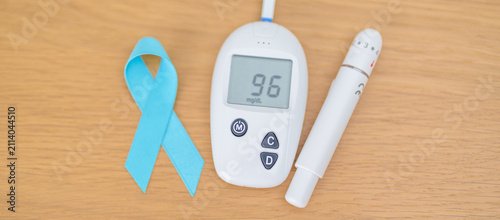 Foto digital blood glucose meter with lancet pen and Blue Ribbon on table