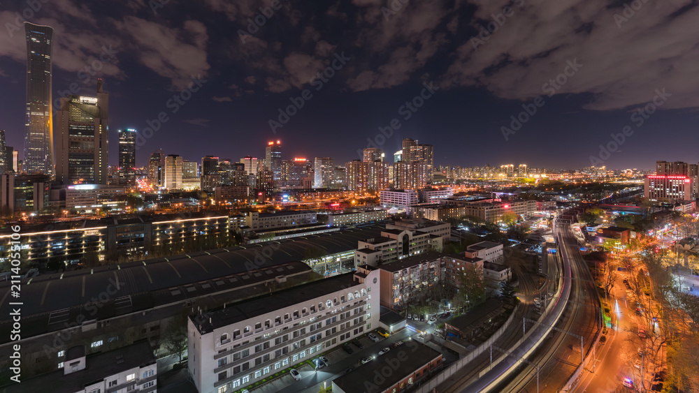 Fototapeta premium The dazzling skyline of Beijing's CBD and the dynamic night view of the railway tracks