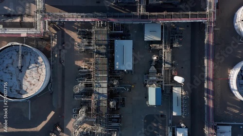 Aerial view of oil refinery with complex network of pipes, storage tanks, and industrial structures