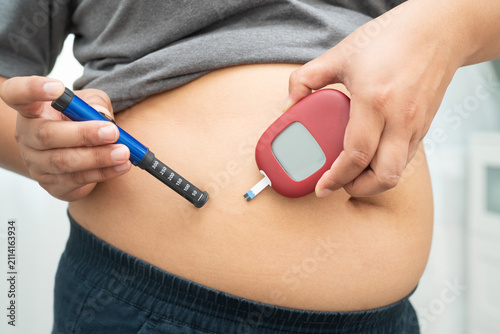 Bild auf Leinwand Asian woman injecting herself diabetes injecting insulin in stomach at home