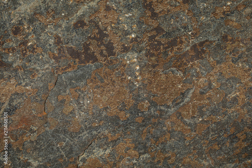 Natural rusty ironstone slate stone texture with rough mineral surface background. Weathered iron mineral deposits, dark grey slate layers, and subtle cracks.