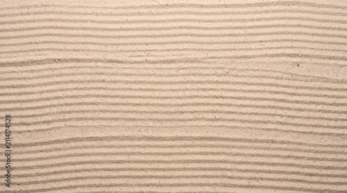Smooth raked sand with fine parallel ripples in soft warm light