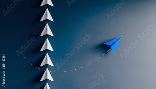 Leadership concept with paper planes. Unique blue plane leading a group of white followers.