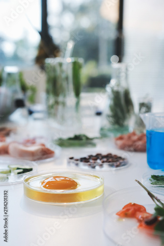 Scientists in lab coats work with plants in a modern lab, focusing on research and experimentation under bright, sterile conditions.