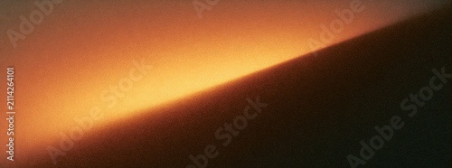 Abstract gradient of warm orange light against a dark shadow