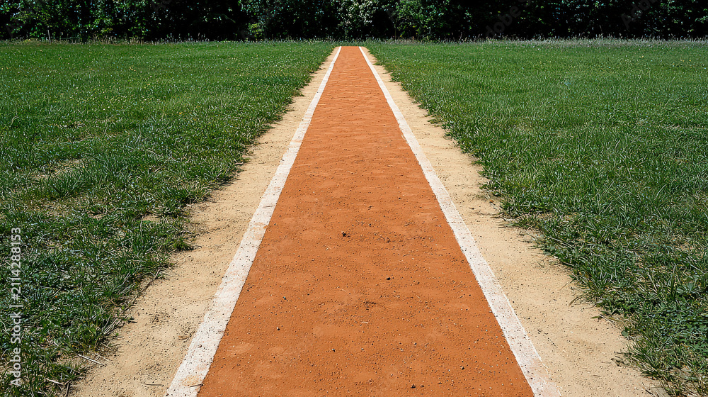 Obraz premium Sports field track lane grass finish line path outdoor athletics empty track lane crossing grassy sports field path outdoor competition area with
