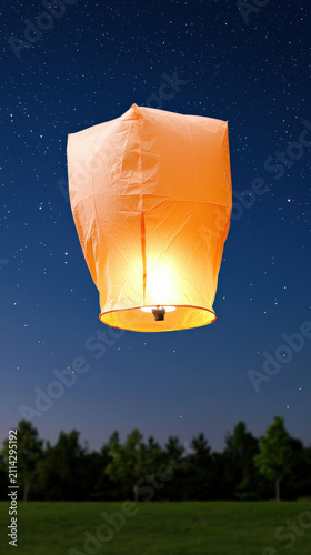 Glowing lantern sky star night orange paper flame light, glowing paper lantern floating into dark sky above field