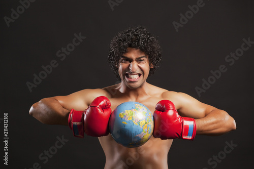 Fotografie Portrait of young boxer breaking globe