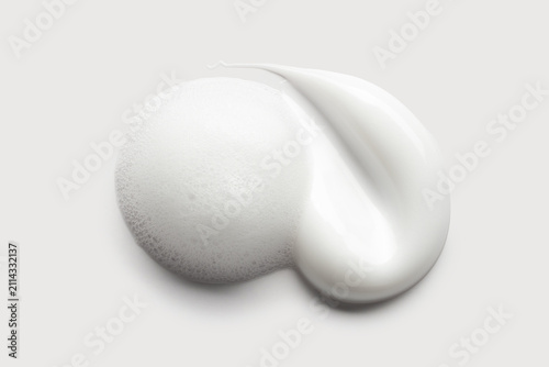 samples of cosmetic care products smear of cream and foam texture on a light background