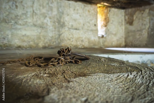 Close-up of authentic iron chains and shackles display in underground slave chamber in Mkunazini, Zanzibar. Somber historic artifact in a dimly lit Stone Town dungeon