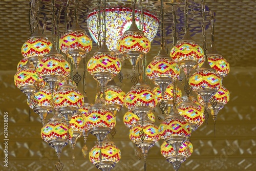 A mosaic of warm colors and fine glass light fills the interior of the main chedi. The chandelier looks like a floating mandala, whose glowing patterns deepen the silence of the sanctuary. Each lamp shines its own spark of insight, carried by the golden glow of the temple. Wat Phra That Sorn Kaew, Khao Kho Mountains, Phetchabun, Isan, Thailand