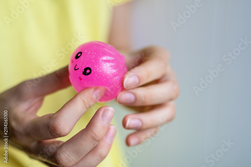 Close-up of hands holding a pink squishy toy before squeezing during sensory play. Concept of stress relief, tactile activity, relaxation and emotional balance.
