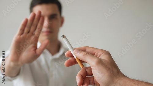 Man refusing cigarette with stop hand gesture promoting no smoking and healthy lifestyle