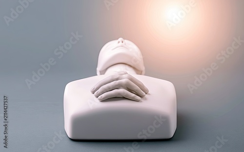 White bust of a person with hands clasped over chest, soft light above