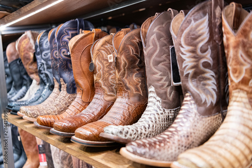 Variety of fashion cowboy leather boots. Fashionable footwear clothes. Fashion footwear store. Boot male fashion shop. Shopping cowboy boots. Stylish western shoes boutique. Choosing western shoes