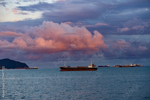 Fotografie Cargo Ships Anchored off the Coast of Busan Beneath Dramatic Sunset Clouds, Sout