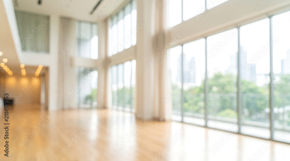 Fototapeta premium Out of focus modern office building interior with large windows and bright natural light for business corporate background and professional commercial real estate marketing