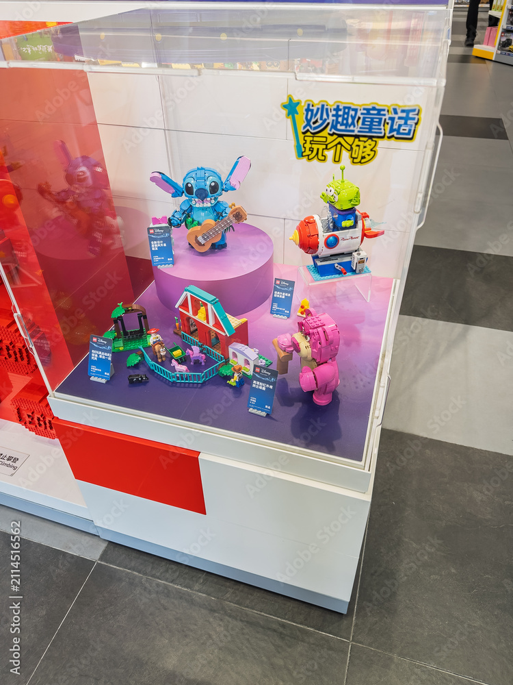 Fototapeta premium LEGO Disney toy display featuring assembled Stitch with ukulele, Lotso bear, and Alien rocket sets inside a transparent showcase in store. Editorial use only. Shanghai, China, 05-25-2026