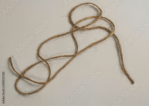 Fotografía High angle close up shot of eco-friendly brown jute twine string loosely coiled on a clean light grey background, designed for craft, sustainable packaging, DIY, and tying concept materials
