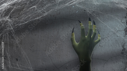 Fotografie A spooky, ghoulish hand with long, sharp, dark fingernails reaching out from a c