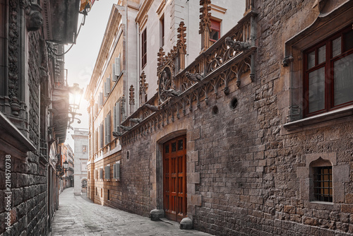 Barcelona, Spain. Barri Gotic Quarter. Antique stone walls with sculptures of medieval buildings in in old town. Famous touristic landmark and travel destination. Sunset evening street perspective.