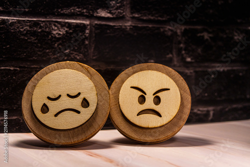 Картината върху платно Wooden emoji craft pieces showcasing sorrowful and angry expressions