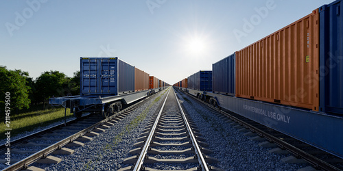 Obraz na płótnie Low angle view between two container trains on tracks at sunset