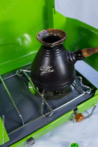 Foto A turk for making morning coffee on a gas stove for camping, the concept of indo