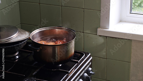Cuadro en lienzo Cooking a meal eggs on an old gas stove, a metal pot boiling food with steam ris