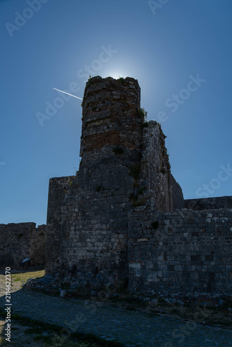 Ancient stone tower of Rozafa Castle backlit by sun Albania