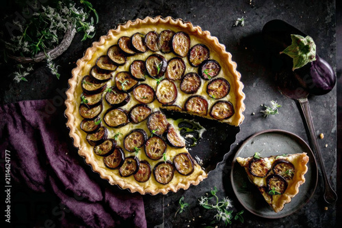 Eggplant, tomato, and mozzarella pie served with olive oil on a cooling rack in a kitchen setting