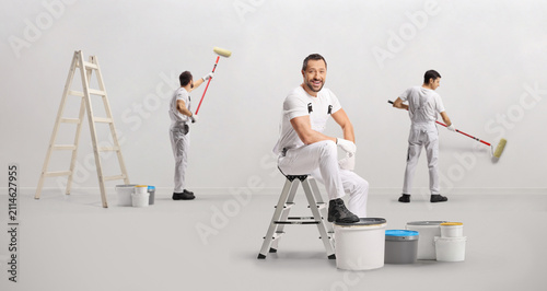 Team of professional painters working and painting a wall